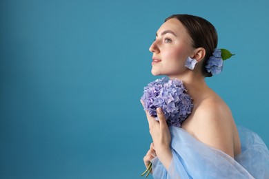 Photo of Portrait of beautiful woman with hortensia flowers on blue background. Space for text