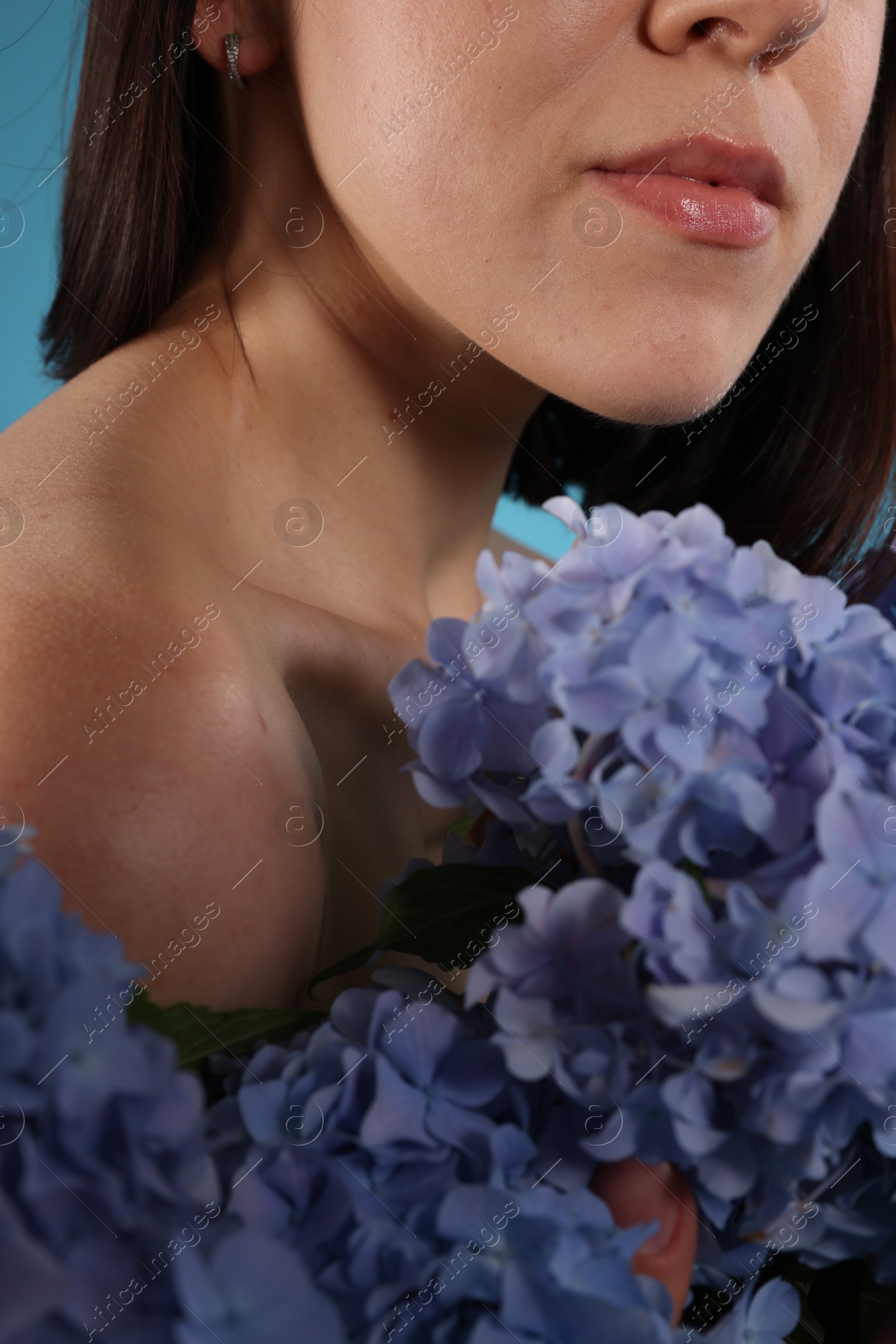 Photo of Young woman with blue hortensia flowers, closeup