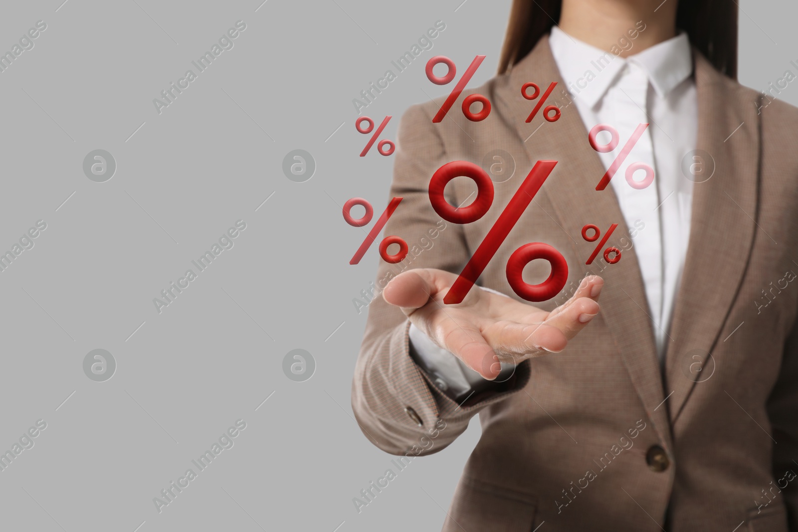 Business woman holding virtual percent signs against grey background, closeup Image of Business woman holding virtual percent signs against grey background, closeup