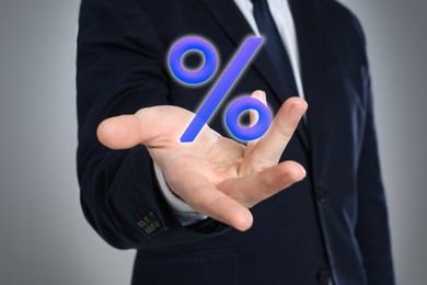 Image of Businessman holding virtual percent sign against grey background, closeup