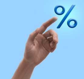 Image of Man touching virtual percent sign against light blue background, closeup