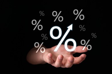 Image of Man holding virtual percent signs in darkness, closeup