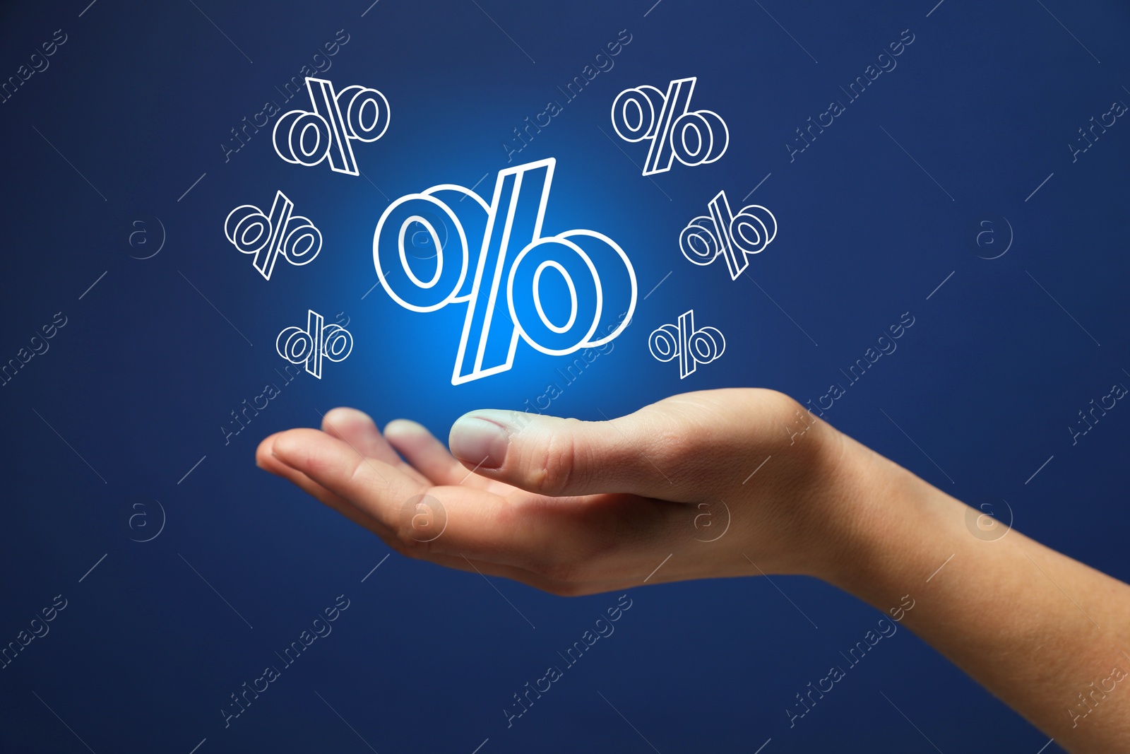 Woman holding virtual percent signs against dark blue background, closeup Image of Woman holding virtual percent signs against dark blue background, closeup