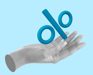 Image of Percent sign in woman's hand against light blue background, closeup
