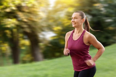 Image of Woman in sportswear running outdoors, motion blur effect