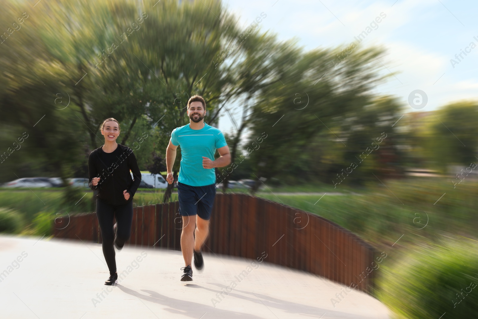 Woman and man in sportswear running outdoors, motion blur effect Image of Woman and man in sportswear running outdoors, motion blur effect