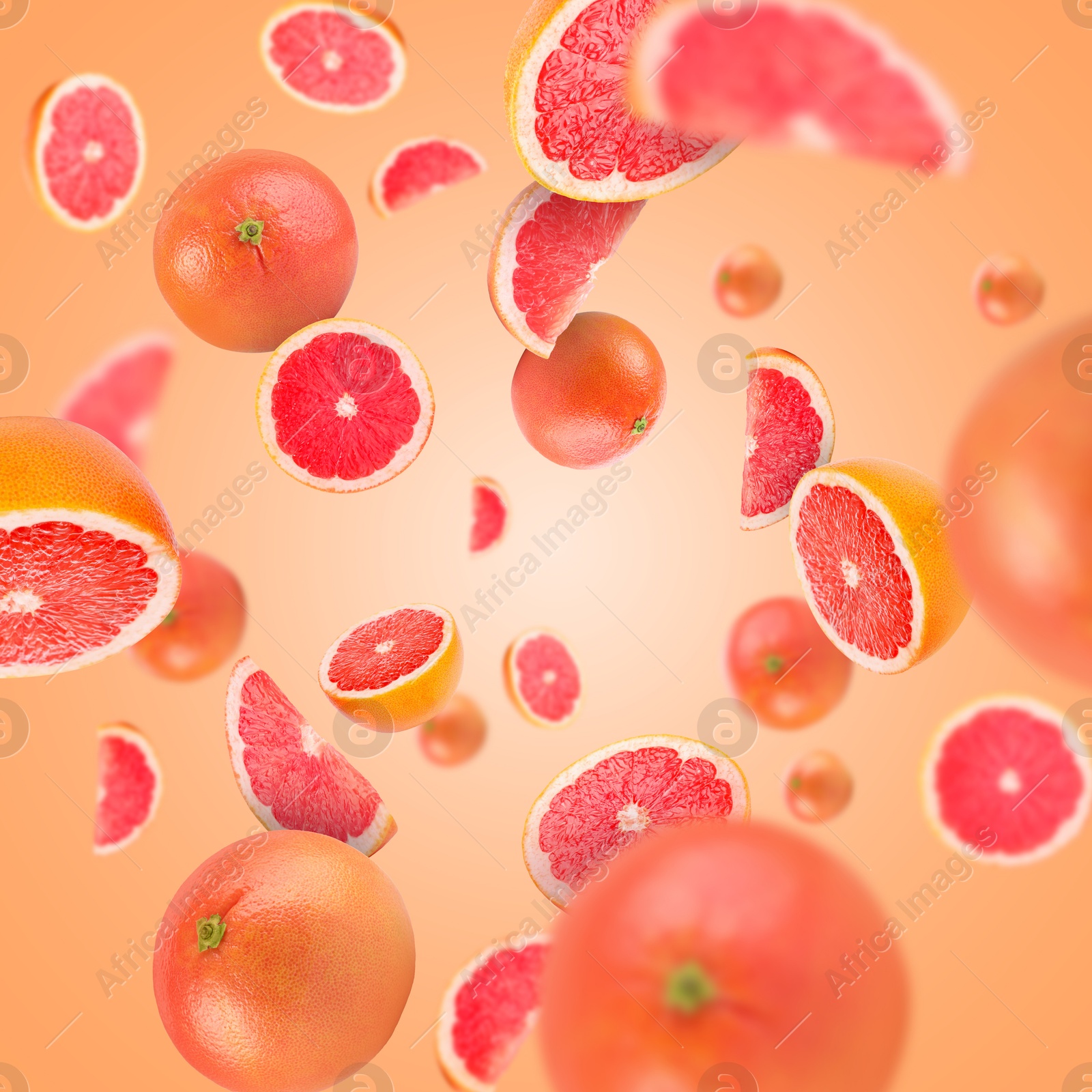 Image of Fresh grapefruits swirling in air against coral background