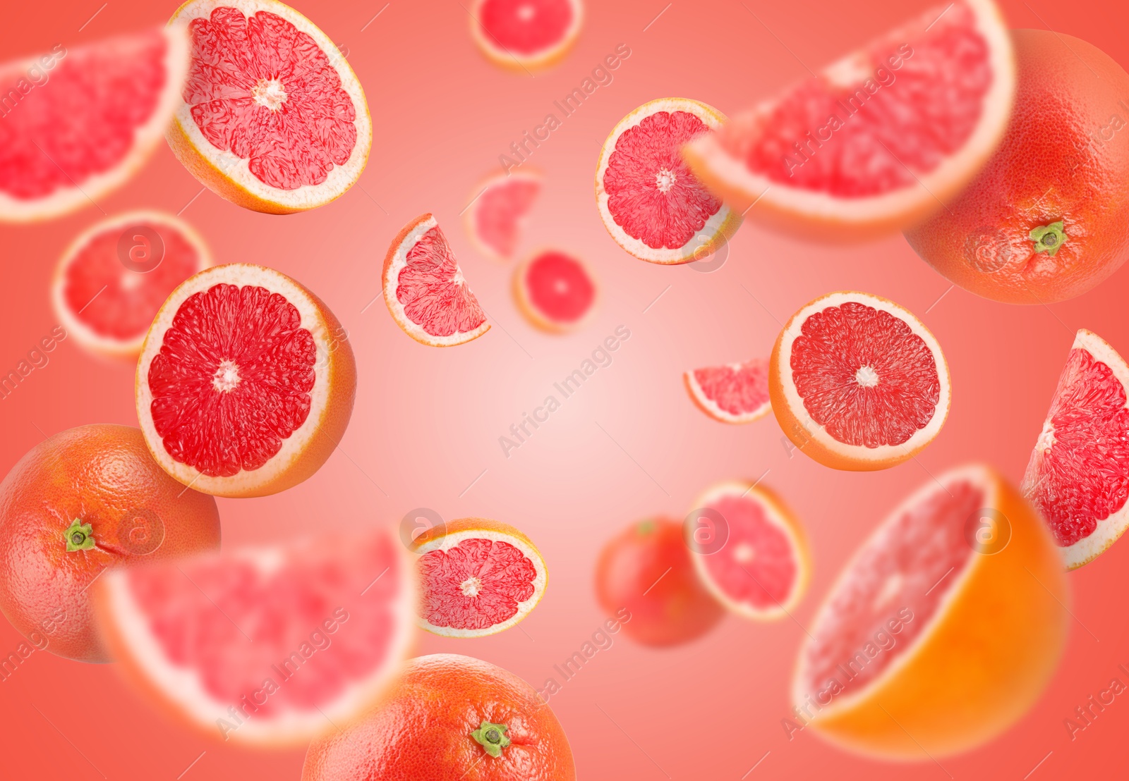 Image of Fresh grapefruits swirling in air against coral background