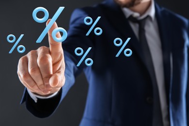 Image of Businessman touching virtual percent sign against dark grey background, closeup