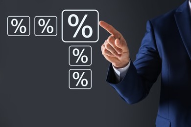 Image of Businessman touching percent sign on virtual screen against dark grey background, closeup