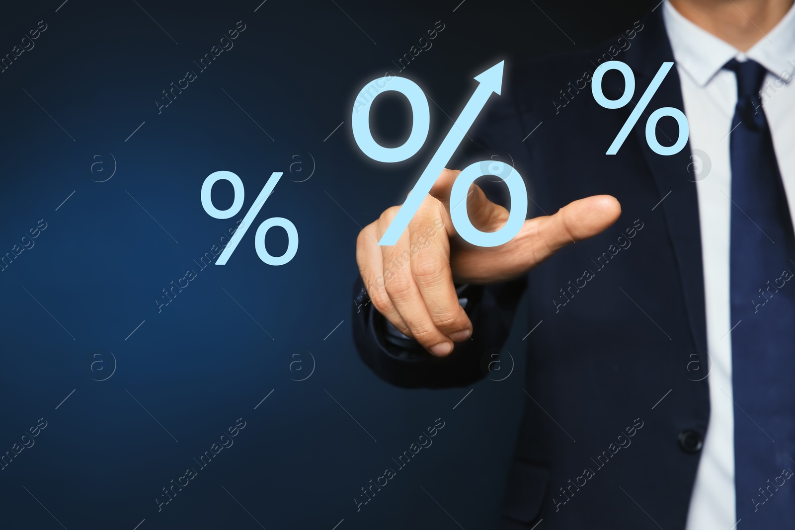 Businessman touching virtual percent sign against dark blue background, closeup Image of Businessman touching virtual percent sign against dark blue background, closeup