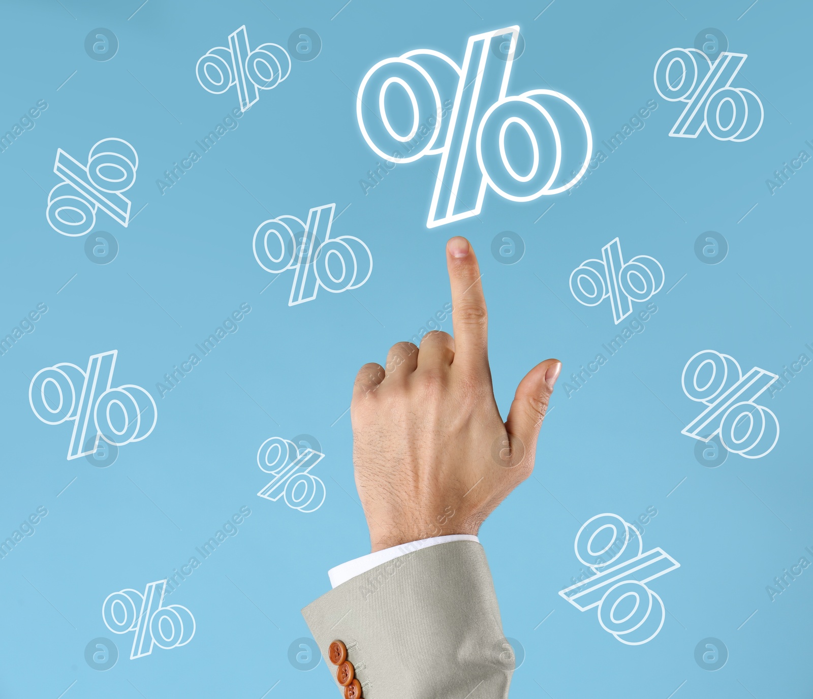 Businessman pointing at virtual percent sign against light blue background, closeup Image of Businessman pointing at virtual percent sign against light blue background, closeup