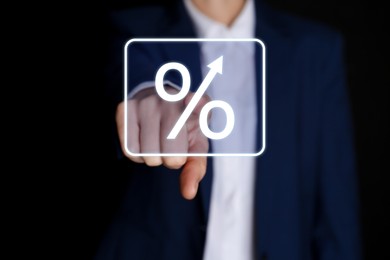 Image of Businessman touching percent sign on virtual screen against black background, closeup