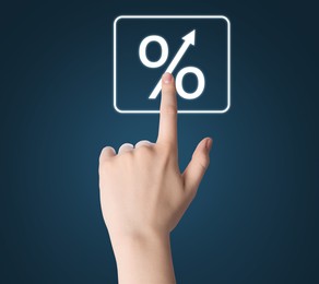 Image of Woman touching percent sign on virtual screen against dark blue background, closeup
