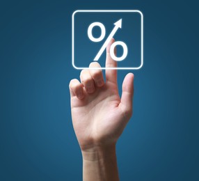 Image of Man touching percent sign on virtual screen against blue background, closeup