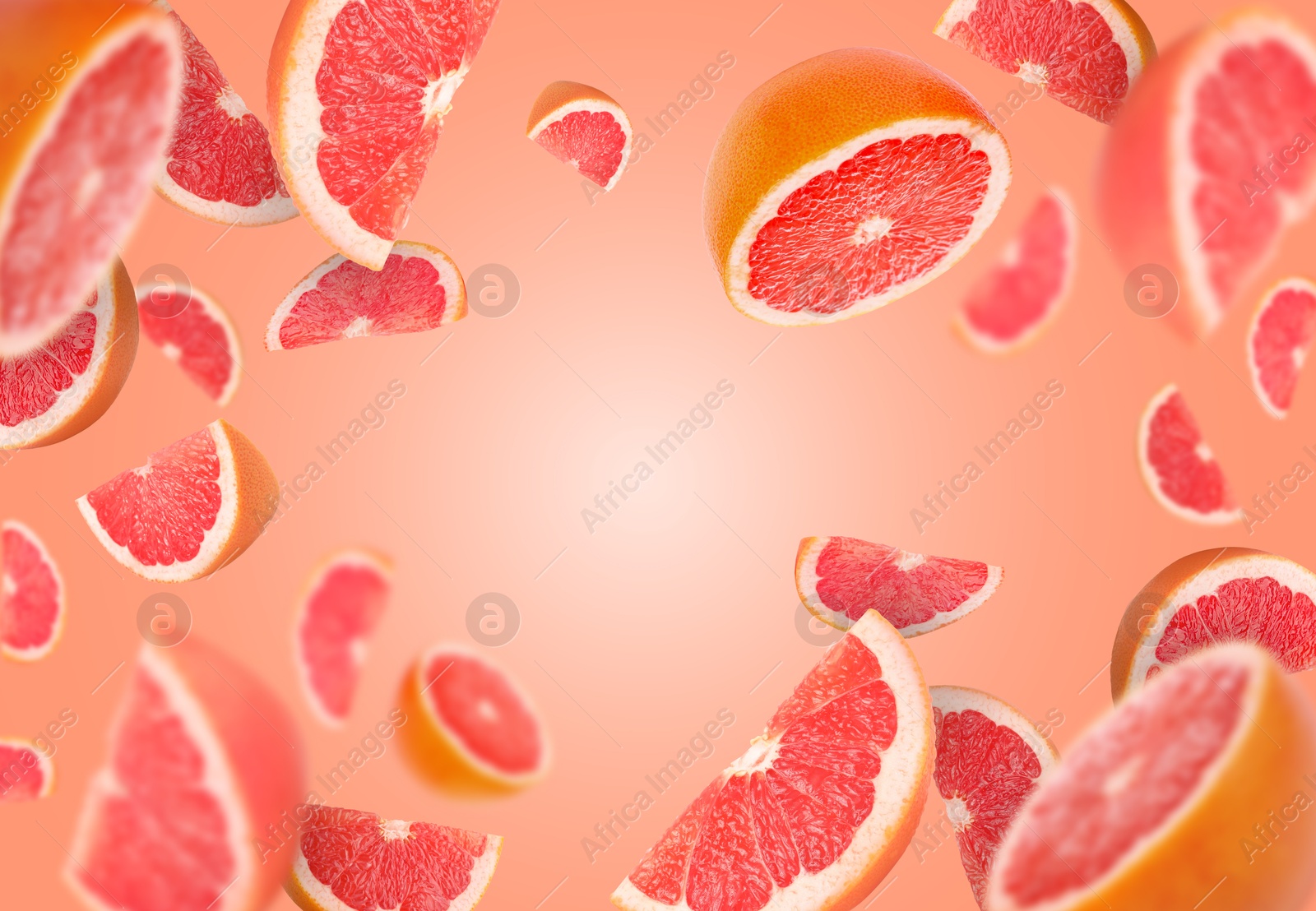 Image of Fresh grapefruits swirling in air against coral background