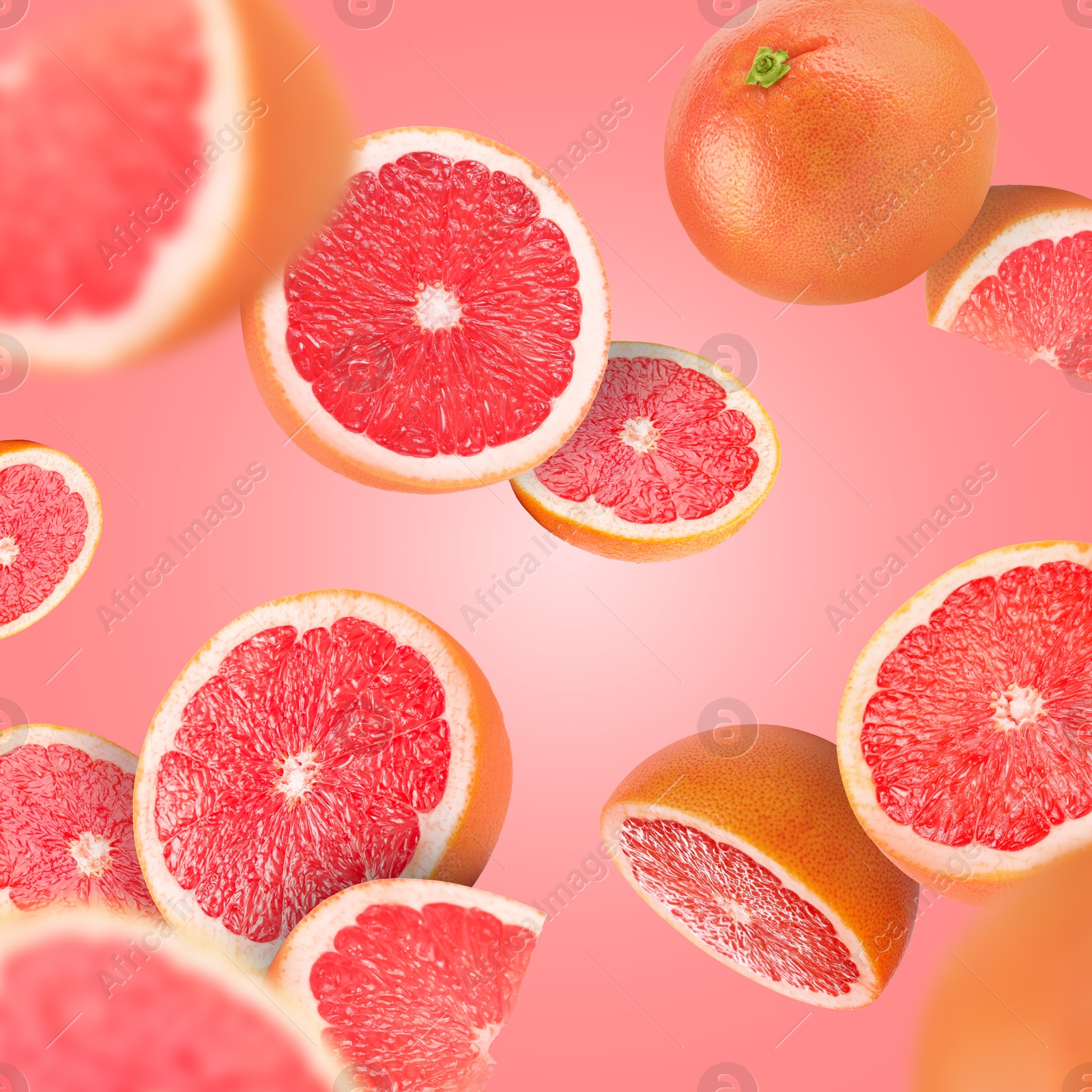 Image of Fresh grapefruits swirling in air against pink background