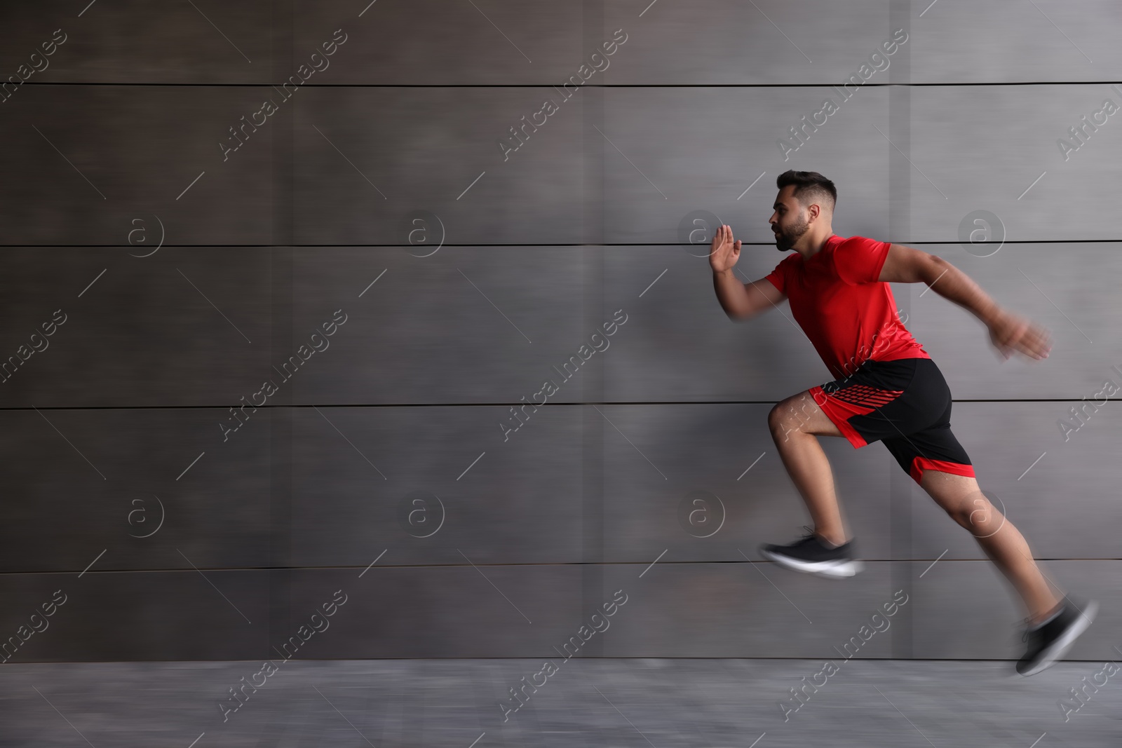 Man in sportswear running near building outdoors, motion blue effect Image of Man in sportswear running near building outdoors, motion blue effect