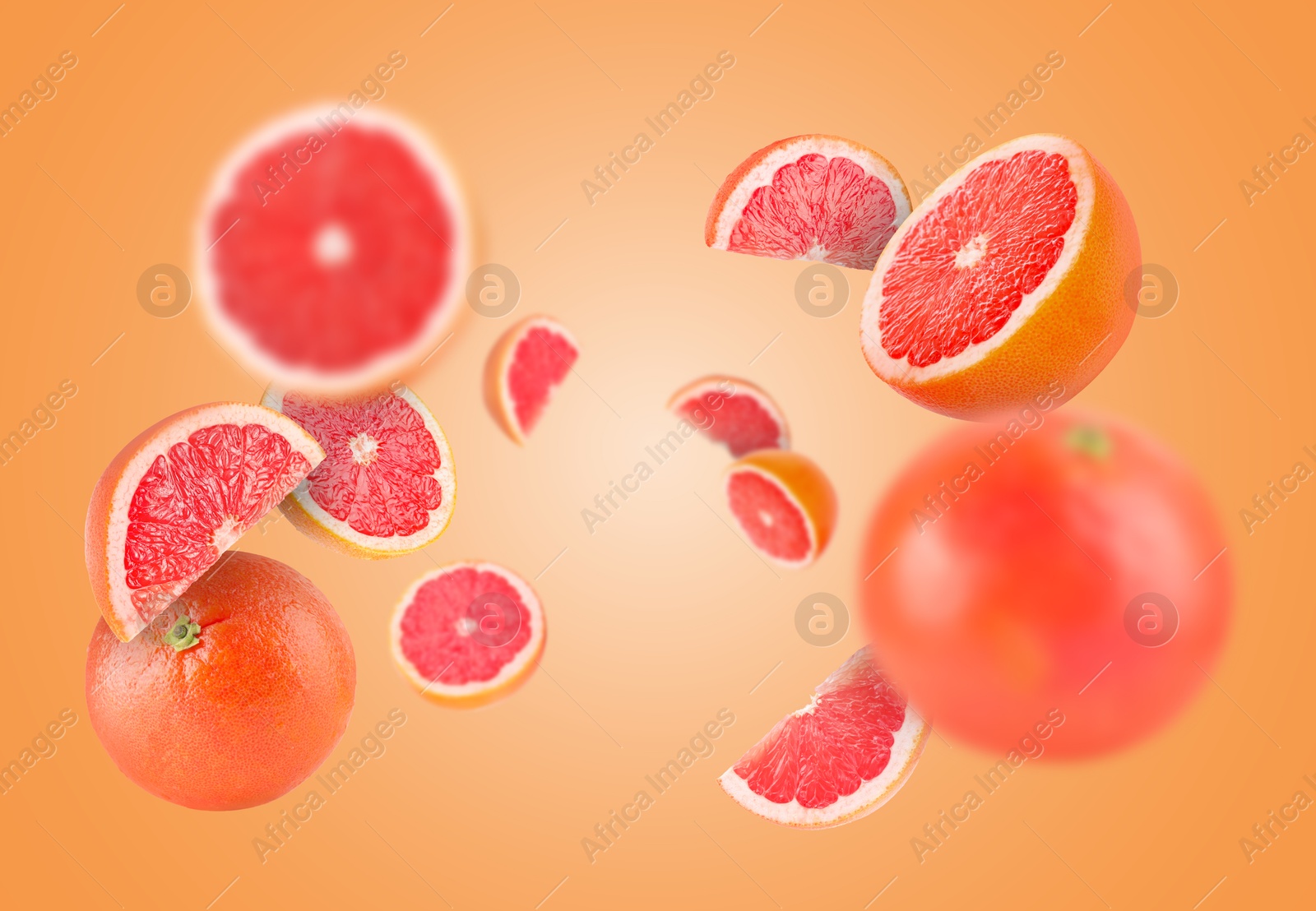 Image of Fresh grapefruits swirling in air against orange background