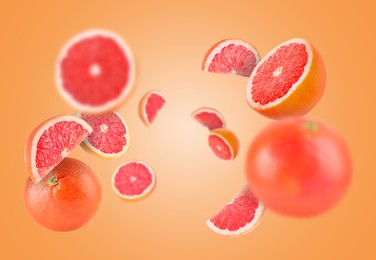 Image of Fresh grapefruits swirling in air against orange background