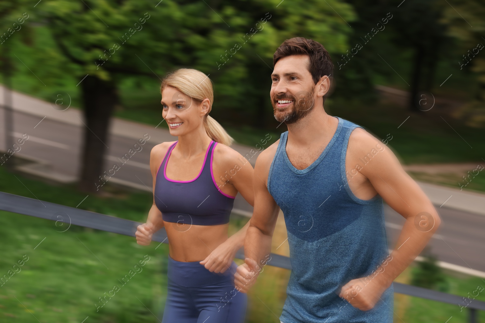 Man and woman in sportswear running outdoors, motion blue effect Image of Man and woman in sportswear running outdoors, motion blue effect
