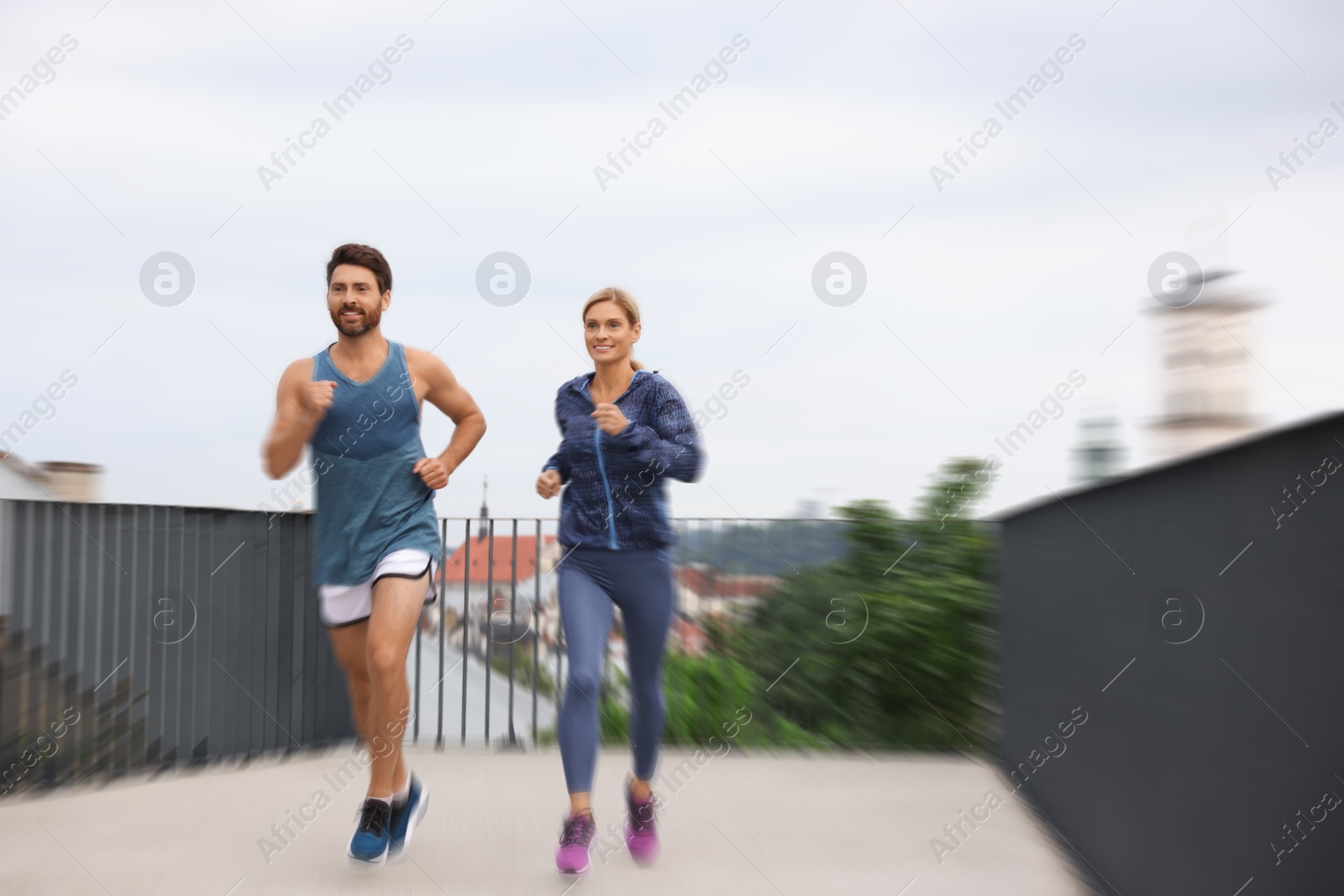 Man and woman in sportswear running outdoors, motion blue effect Image of Man and woman in sportswear running outdoors, motion blue effect