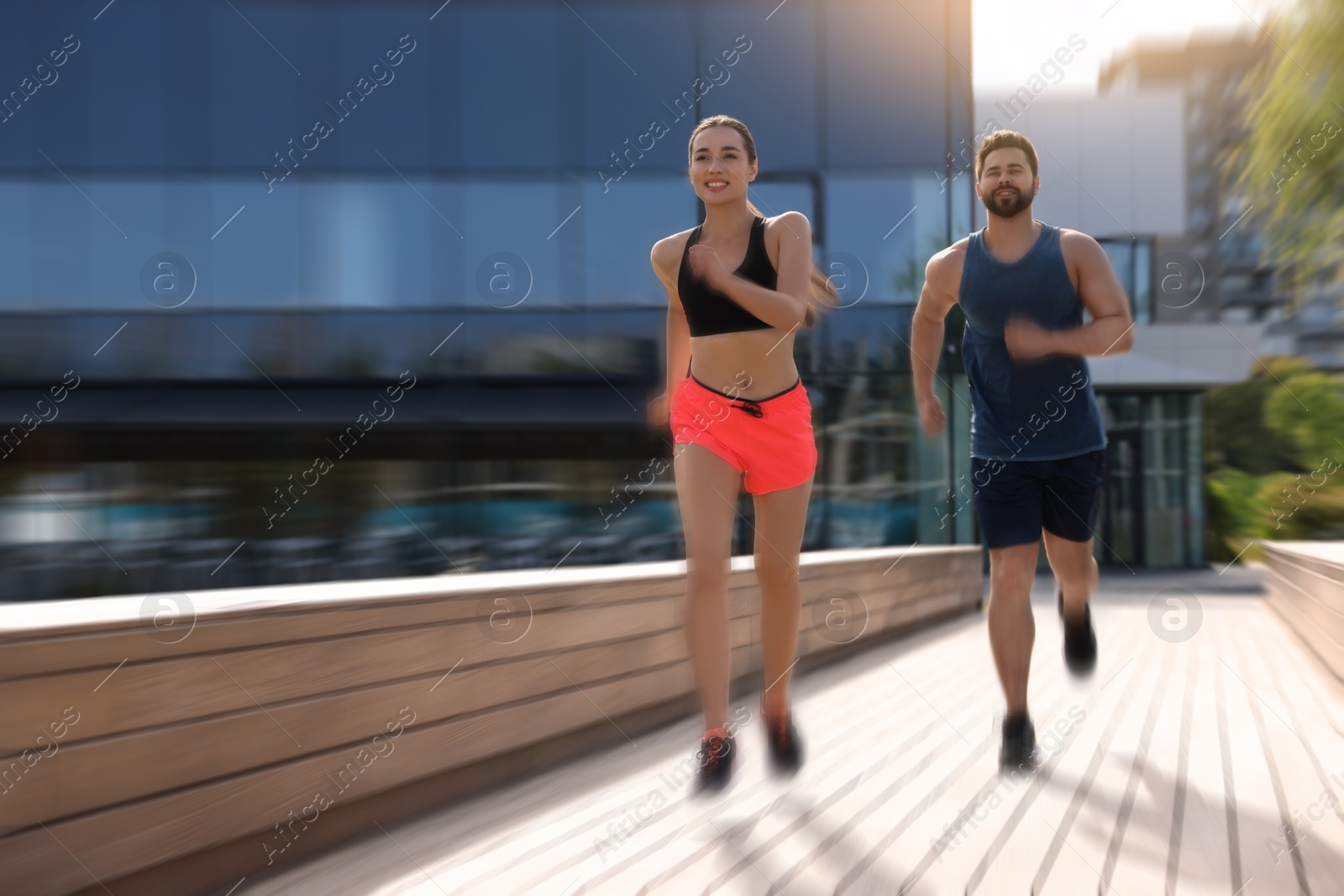 Man and woman in sportswear running outdoors, motion blue effect Image of Man and woman in sportswear running outdoors, motion blue effect