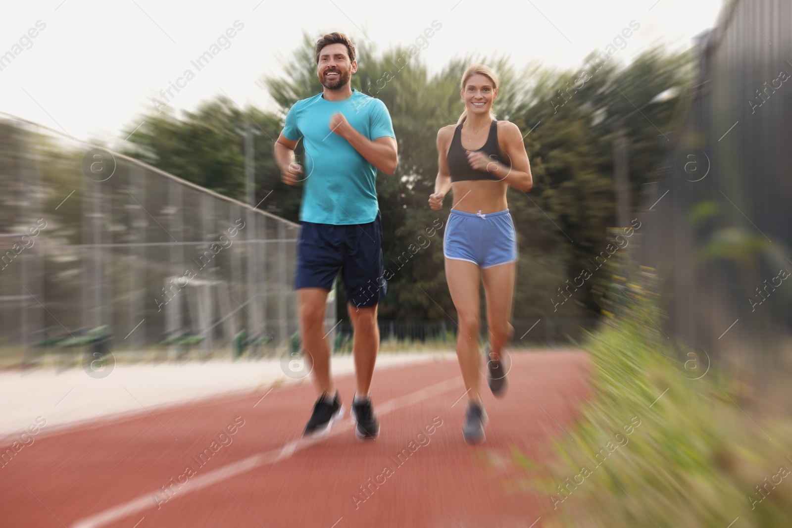 Man and woman in sportswear running outdoors, motion blue effect Image of Man and woman in sportswear running outdoors, motion blue effect