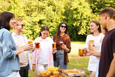 Photo of Group of happy friends having fun and drinking beer outdoors