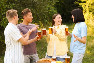 Photo of Group of happy friends clinking glasses of beer outdoors