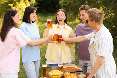 Photo of Group of happy friends clinking glasses of beer outdoors