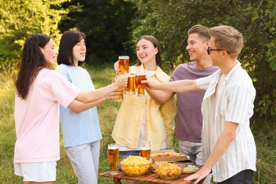 Photo of Group of happy friends clinking glasses of beer outdoors