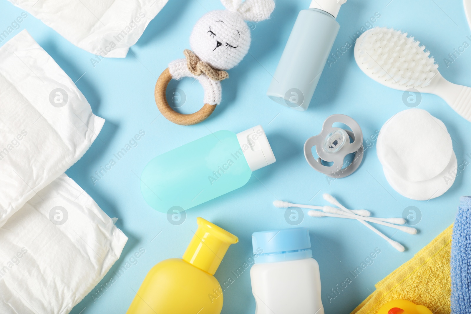 Photo of Baby accessories and cosmetic products on light blue background, flat lay