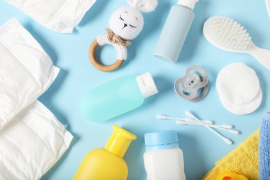 Photo of Baby accessories and cosmetic products on light blue background, flat lay