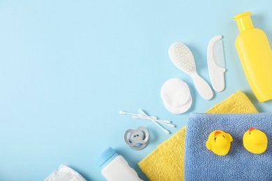 Photo of Baby accessories and cosmetic products on light blue background, flat lay. Space for text
