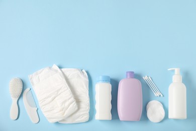 Photo of Baby accessories and cosmetic products on light blue background, flat lay. Space for text