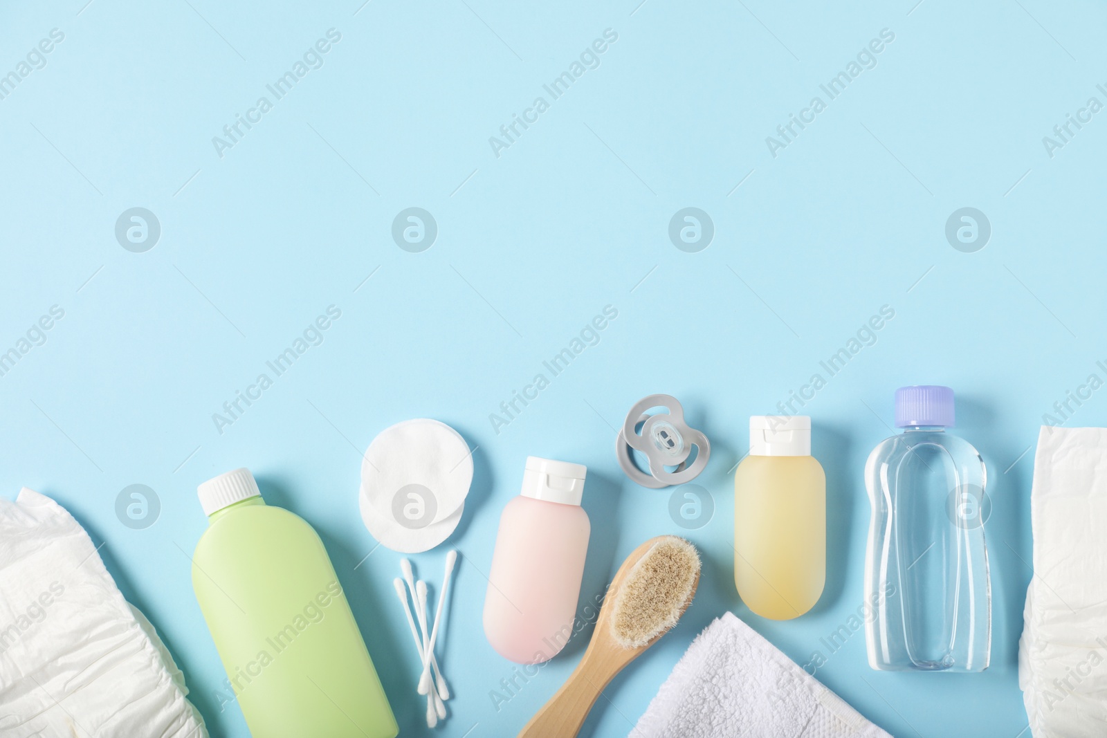 Photo of Baby accessories and cosmetic products on light blue background, flat lay. Space for text