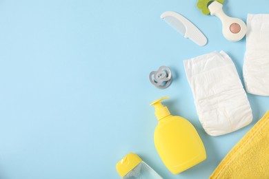 Photo of Baby accessories and cosmetic products on light blue background, flat lay. Space for text