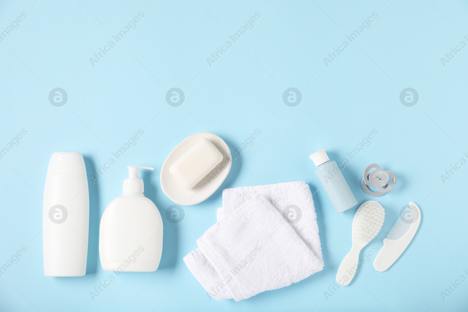 Photo of Baby accessories and cosmetic products on light blue background, flat lay. Space for text