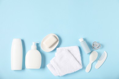 Photo of Baby accessories and cosmetic products on light blue background, flat lay. Space for text