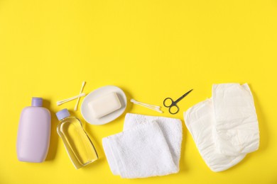 Photo of Baby accessories and cosmetic products on yellow background, flat lay. Space for text