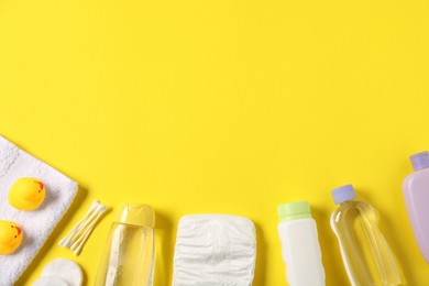 Photo of Baby accessories and cosmetic products on yellow background, flat lay. Space for text