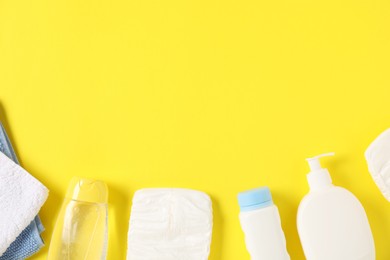 Photo of Baby accessories and cosmetic products on yellow background, flat lay. Space for text