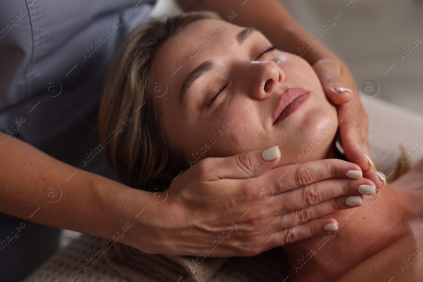 Beautiful woman receiving facial massage in spa salon, closeup Photo of Beautiful woman receiving facial massage in spa salon, closeup