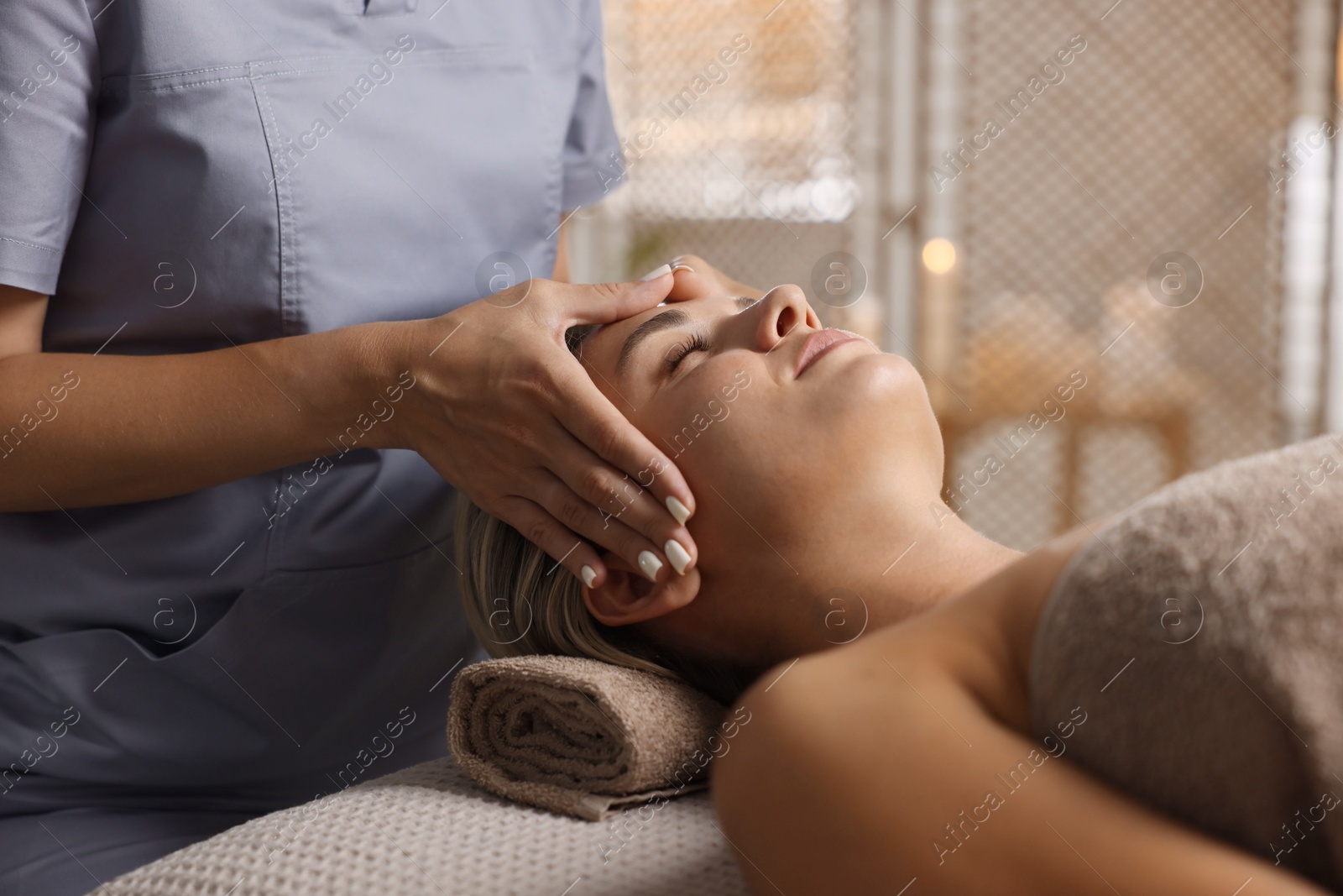 Beautiful woman receiving facial massage on couch in spa salon, closeup Photo of Beautiful woman receiving facial massage on couch in spa salon, closeup