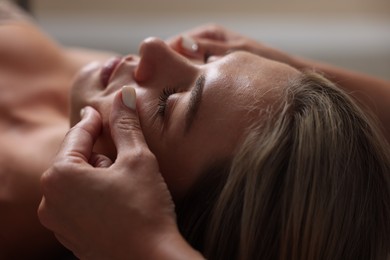 Photo of Beautiful woman receiving facial massage, closeup view