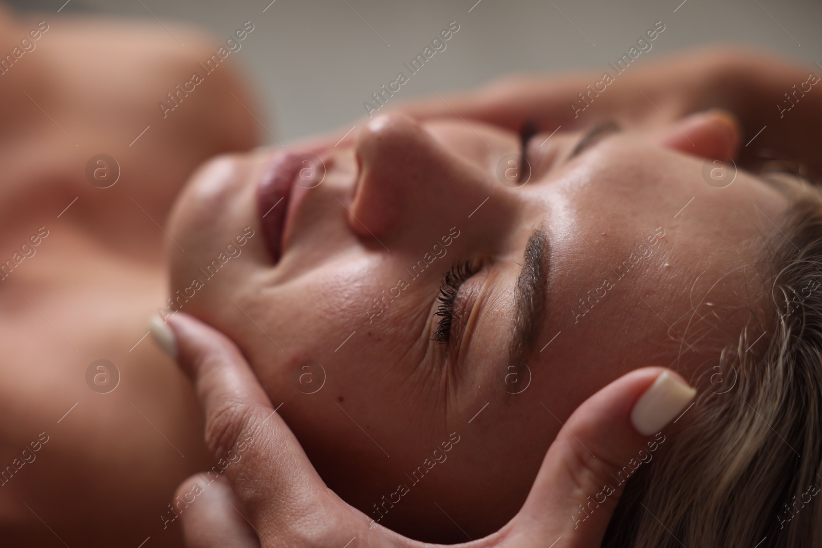 Beautiful woman receiving facial massage, closeup view Photo of Beautiful woman receiving facial massage, closeup view