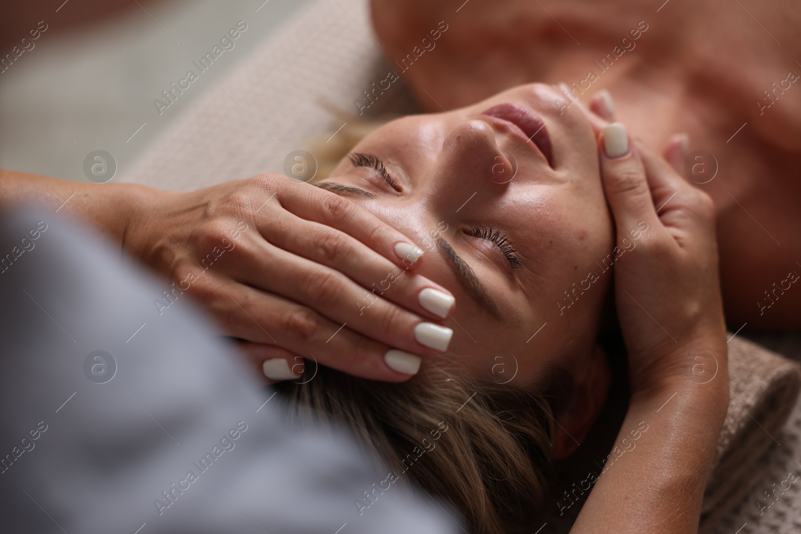 Beautiful woman receiving facial massage on couch, closeup Photo of Beautiful woman receiving facial massage on couch, closeup