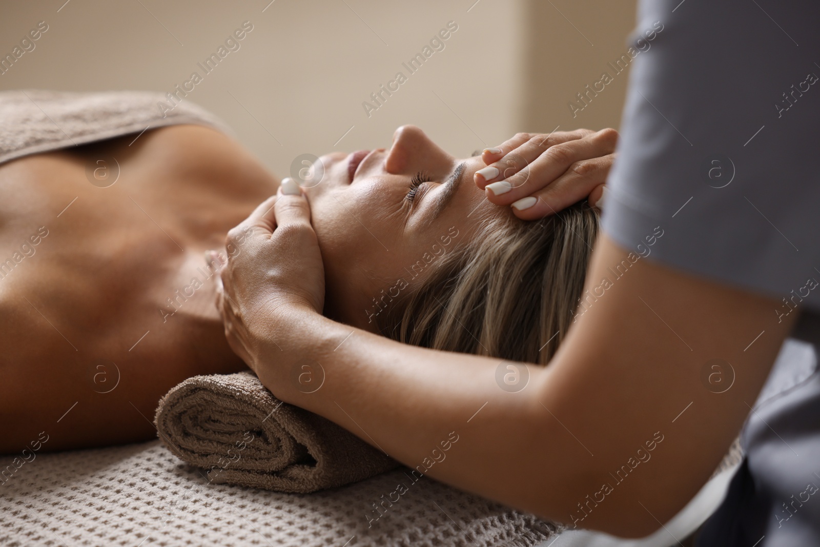 Beautiful woman receiving facial massage on couch in spa salon, closeup Photo of Beautiful woman receiving facial massage on couch in spa salon, closeup