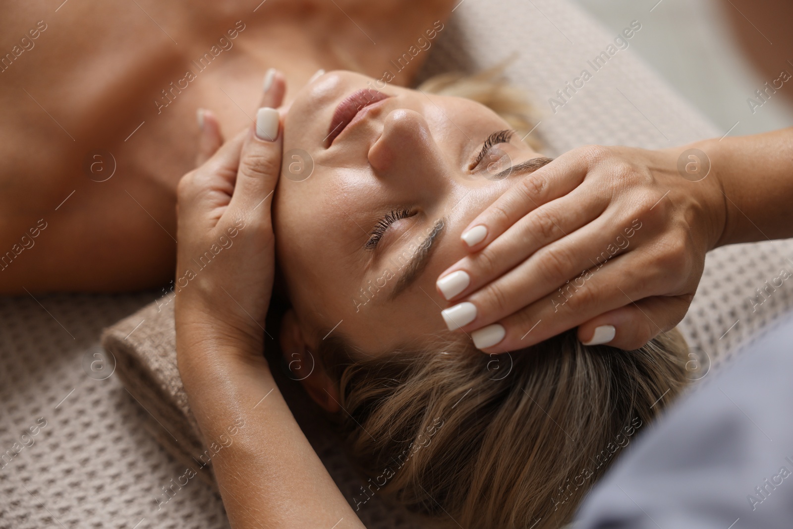 Beautiful woman receiving facial massage on couch, closeup Photo of Beautiful woman receiving facial massage on couch, closeup